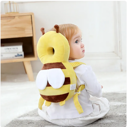 Child wearing a yellow and brown plush backpack with a hood in a room.